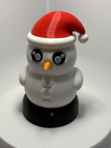 Der Schneemann zeigt einen warm gelb leuchtenden Körper, der durch die drei runden Vertiefungen wie klassische Schneemann‑Knöpfe wirkt.