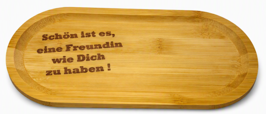 Das Bild zeigt einen elegant gravierten Holz‑Tassenuntersetzer auf einem hellen Tablett. Die Gravur „Schön ist es, eine Freundin wie Dich zu haben!“ ist klar und sauber ausgearbeitet. Daneben steht eine weiße Keramiktasse – dekorativ platziert, jedoch nic